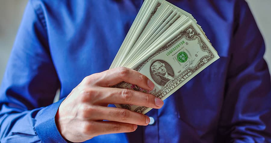 Person Holding a Stack of Dollar Bills